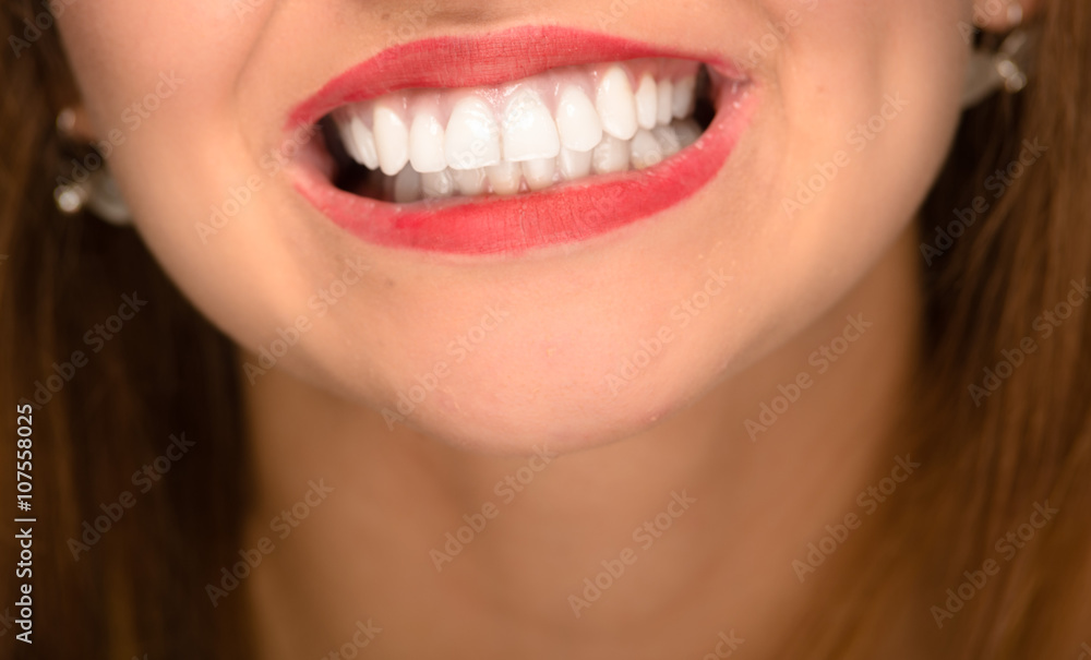 Fototapeta premium Closeup young womans mouth showing white healthy teeth