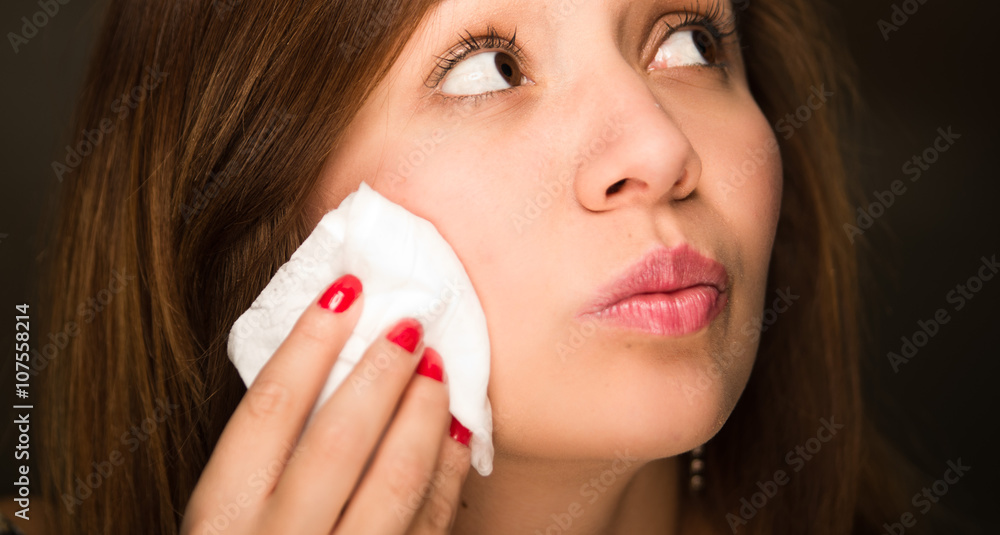 Brunette woman closeup face using cotton pads on chin Brunette woman closeup face using cotton pads on chin