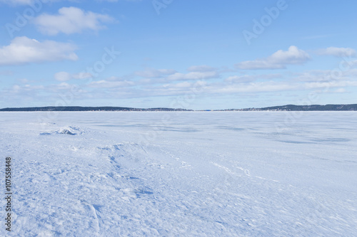 View of frozen northern lake on a clear winter day 