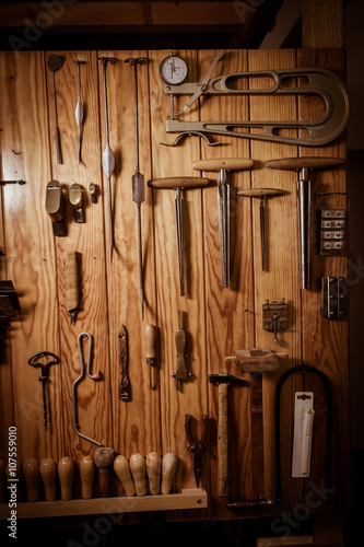 Many different old tools hanging on wall