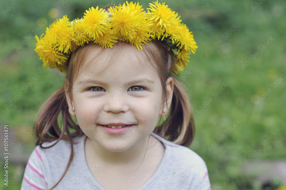 Happy and cheerful girl with a beautiful smile, with a wreath of dandelions. Happy and cheerful girl with a beautiful smile, with a wreath of dandelions.