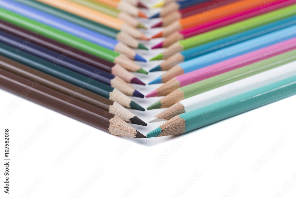 Naklejka premium colored pencils on a blank sheet of paper, ready to be used in design