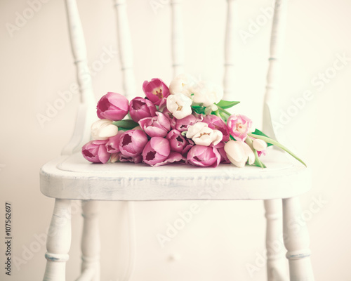 Fototapeta Naklejka Na Ścianę i Meble -  Pink and white tulips in a vintage white wood chair