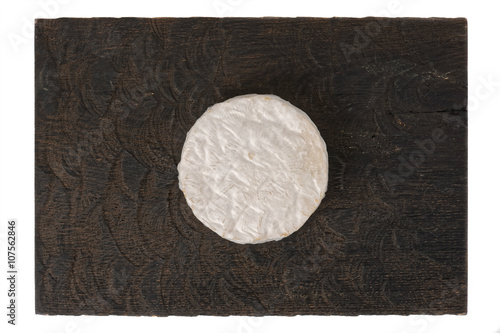 Brie cheese on black wooden board, isolated