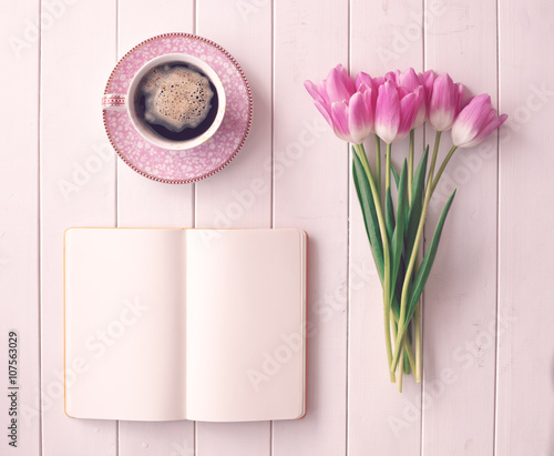 Fototapeta Naklejka Na Ścianę i Meble -  Pink tulips, coffee cup and notebook over white wood