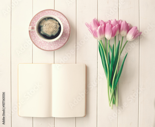 Fototapeta Naklejka Na Ścianę i Meble -  Pink tulips, coffee cup and notebook over white wood