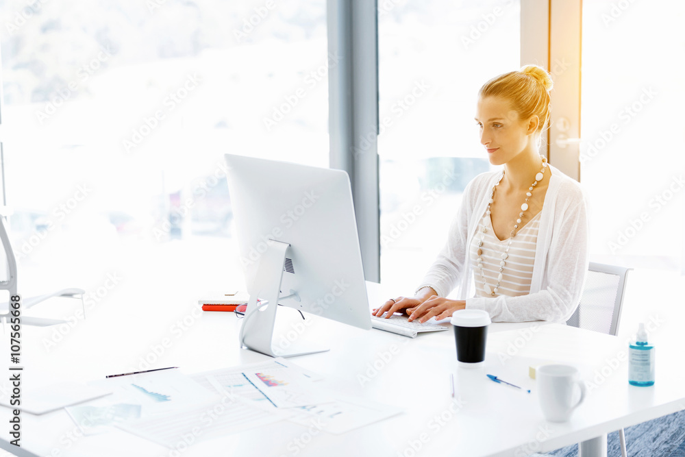 Attractive office worker sitting at desk Attractive office worker sitting at desk