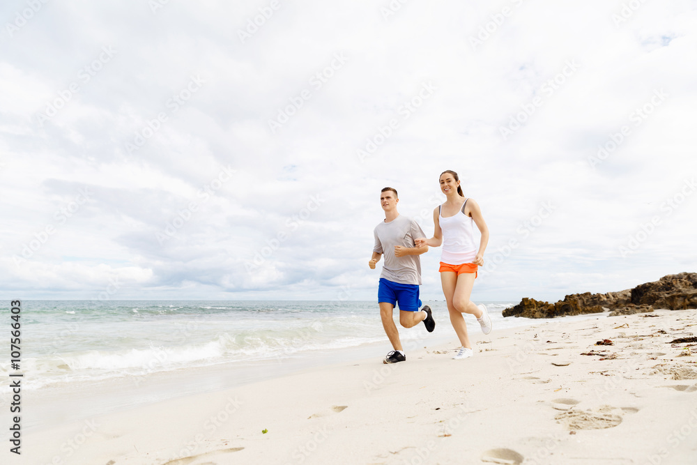 Runners. Young couple running on beach Runners. Young couple running on beach