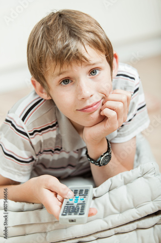 Smiling young boy watching television at home