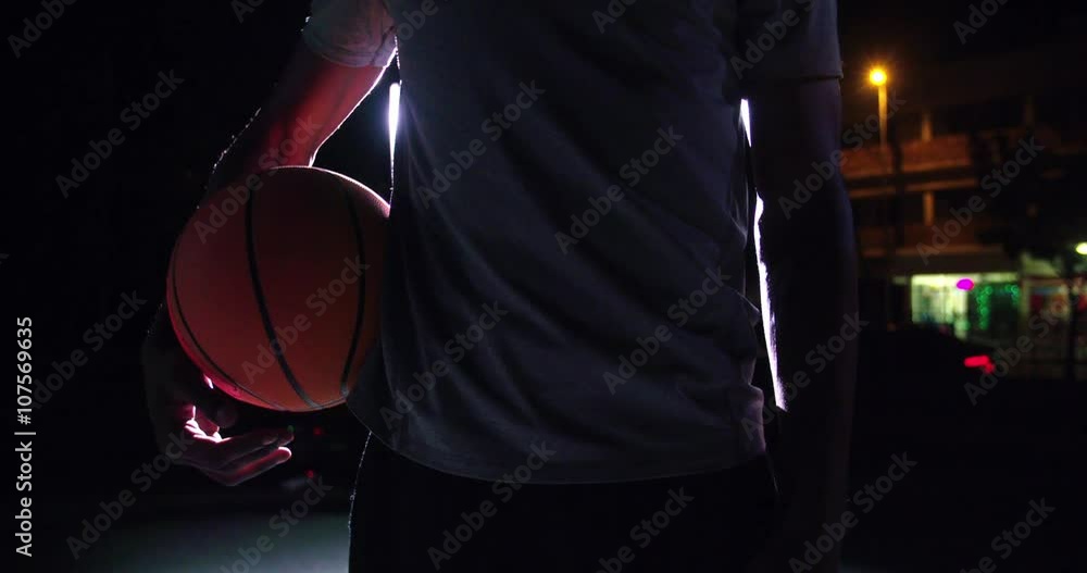 Frontal key shot of basketball player holding ball on hip Frontal key shot of basketball player holding ball on hip