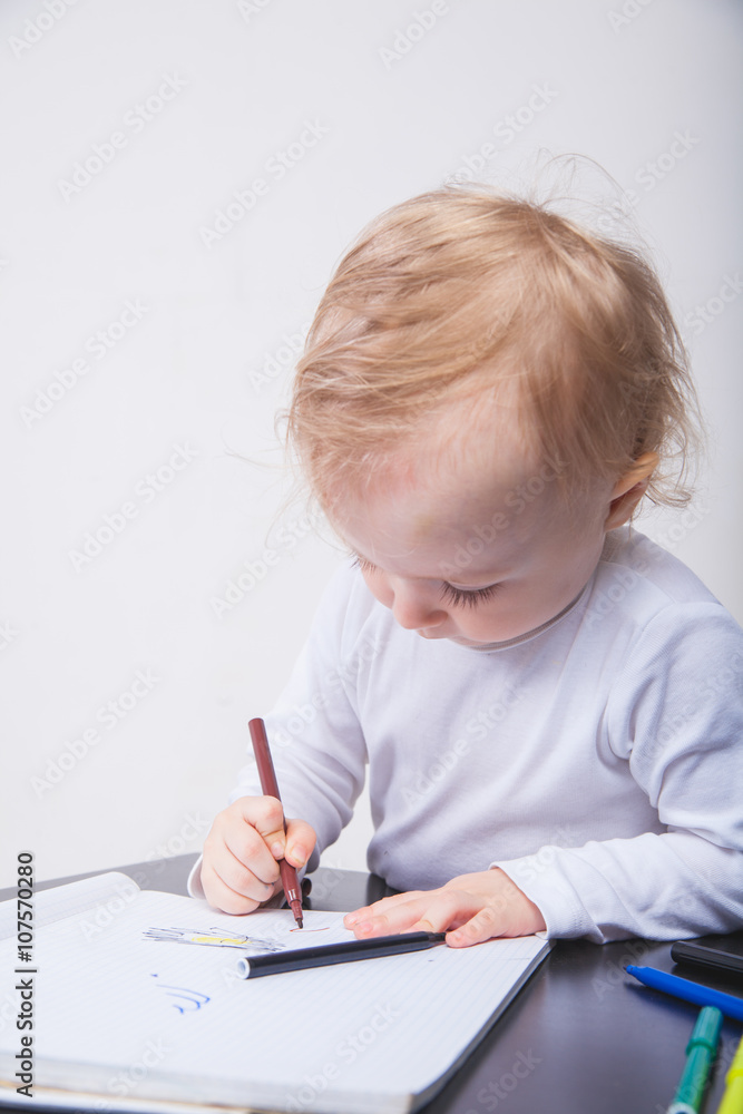 Baby girl drawing with colorful felt-tip pens white background Baby girl drawing with colorful felt-tip pens white background