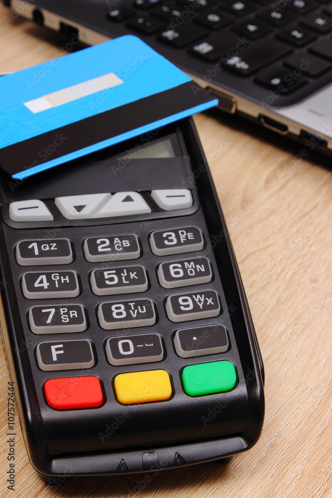 Payment terminal with contactless credit card and laptop, finance concept Payment terminal with contactless credit card and laptop, finance concept