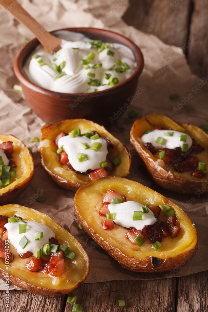 Baked potato skins with cheese, bacon and sour cream close-up. vertical
