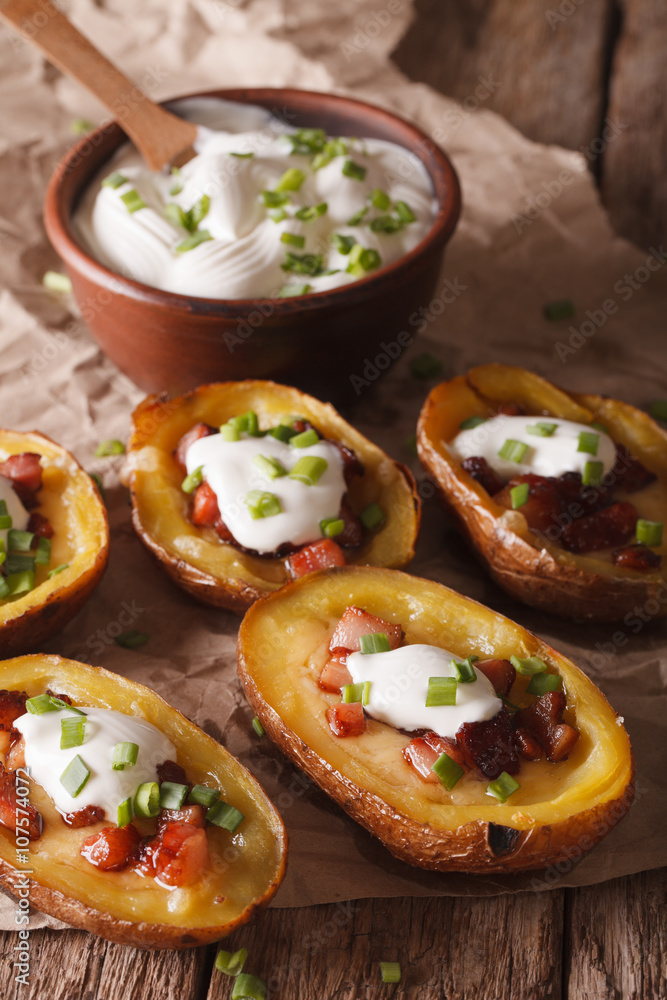 Baked potato skins with cheese, bacon and sour cream close-up. vertical
Baked potato skins with cheese, bacon and sour cream close-up. vertical