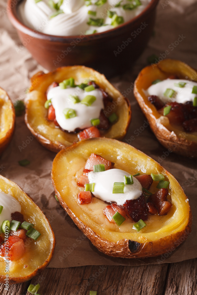 Potatoes stuffed with cheese, bacon and sour cream close-up. Vertical
