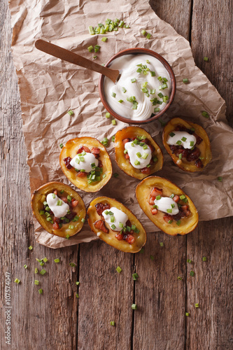 potato skins with cheese, bacon and sour cream on the table. vertical top view
