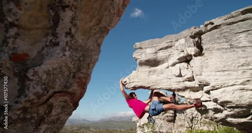 Rock climber holding to boulder and focused on route photo
