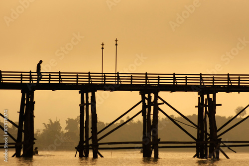 A man on the river wooden bridge