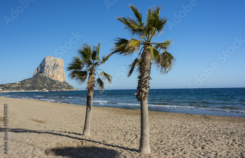 Penon de Ifach, palm trees and the Mediterranean sea in Calpe, Spain.