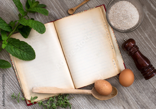 vintage recipe book, ladle and food ingredients over wood