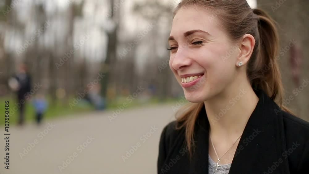 Young pretty girl smiles happily into camera, close up, slow motion Young pretty girl smiles happily into camera, close up, slow motion
