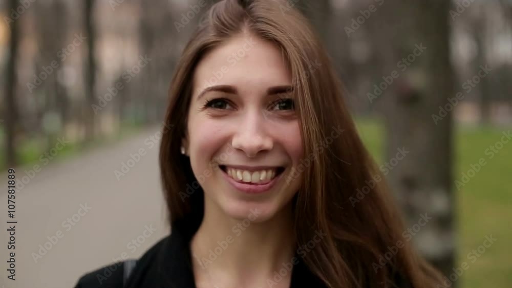 Young pretty girl smiles happily into camera, close up, slow motion Young pretty girl smiles happily into camera, close up, slow motion