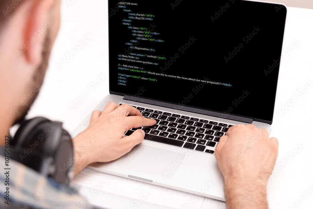 Man using laptop, writing programming code on laptop Man using laptop, writing programming code on laptop