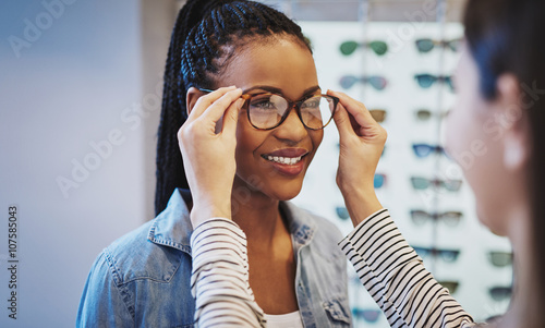 Attractive young African woman selecting glasses