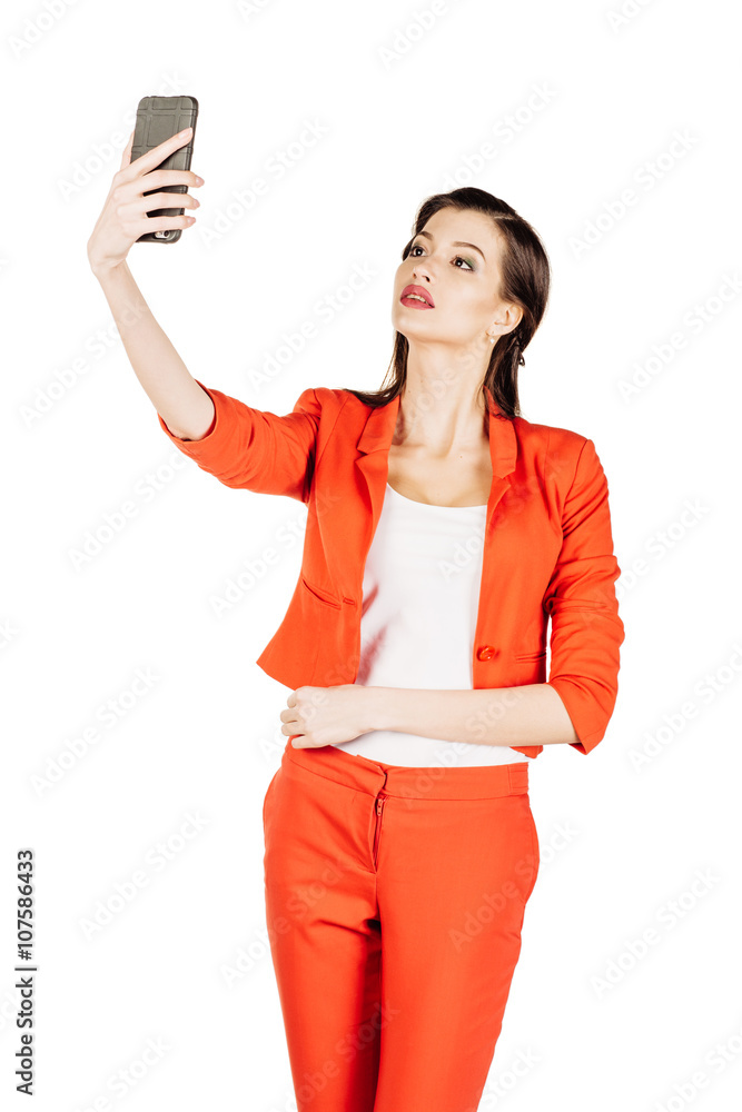 Naklejka premium business woman wearing an orange shirt using a smartphone. 