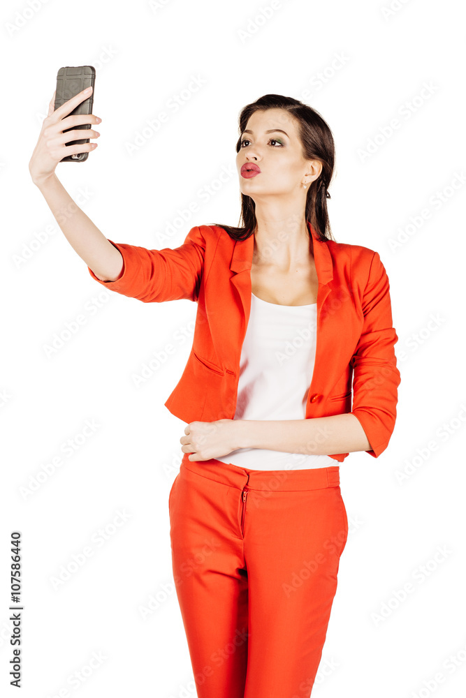 Naklejka premium business woman wearing an orange shirt using a smartphone. 