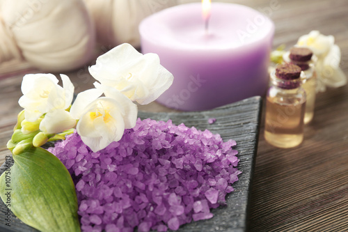 Sea salt crystals in a bowl and exotic flowers  close up