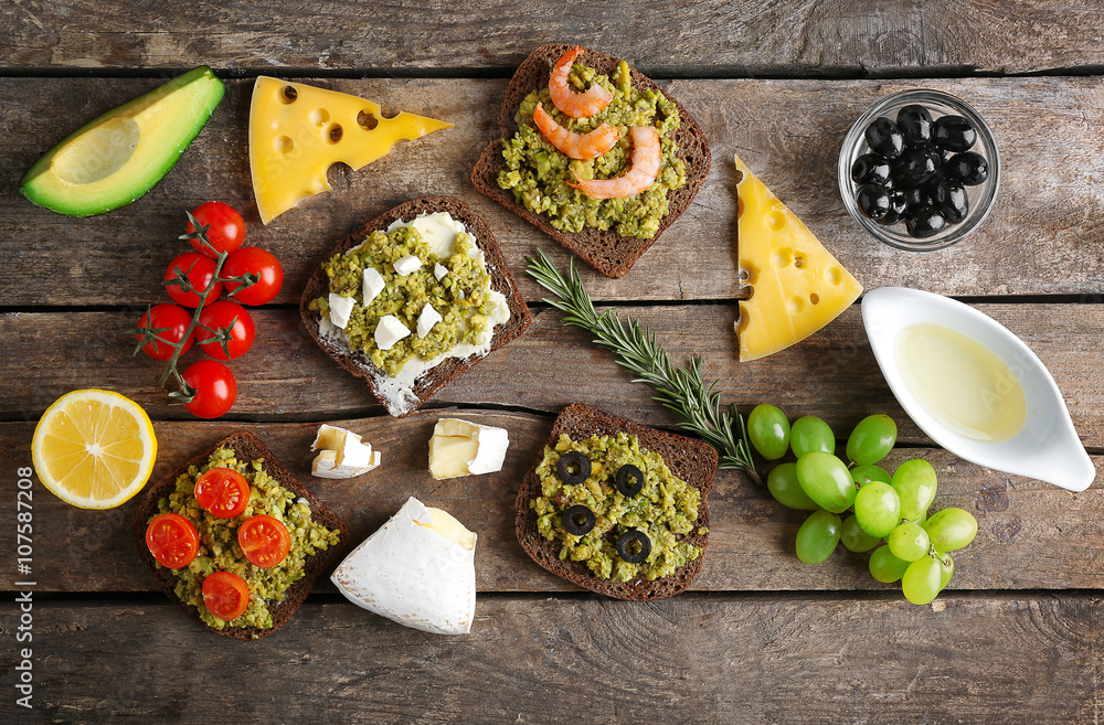 Avocado sandwiches with vegetables on dark wooden background Avocado sandwiches with vegetables on dark wooden background