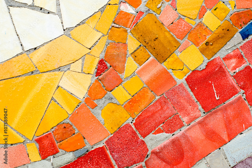 colorful mosaic of ceramic pieces on the wall, typical art Gaudi style in Barcelona, Spain
