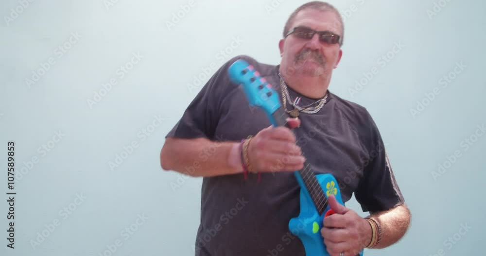 Funny man playing children's toy guitar Funny man playing children's toy guitar