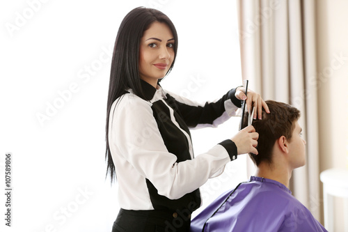 Professional hairdresser making stylish haircut