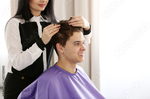 Professional hairdresser making stylish haircut