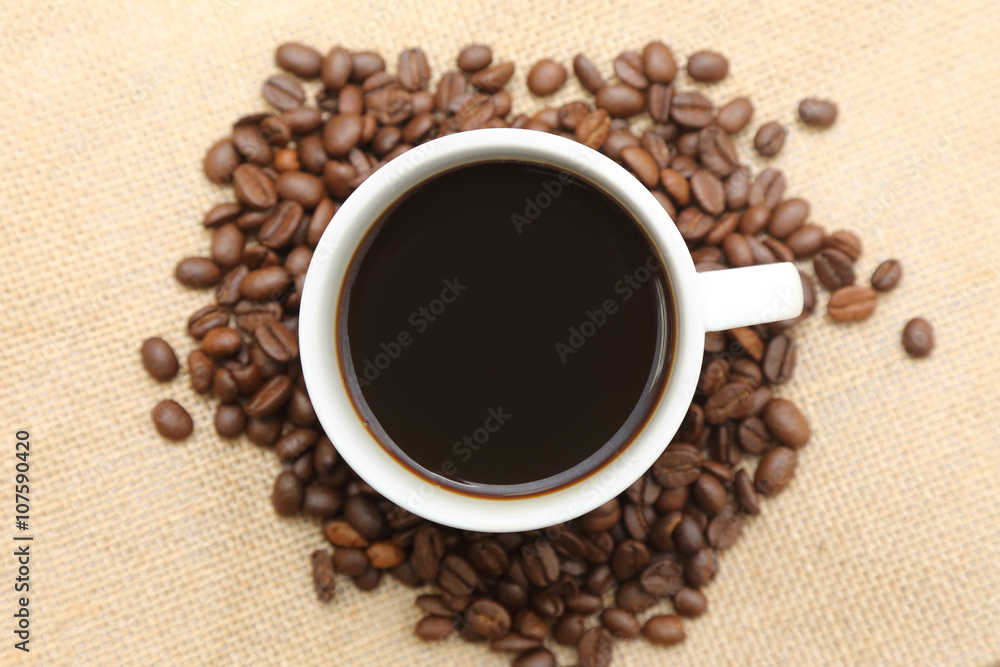 cup of coffee with roasted coffee on burlap sack cup of coffee with roasted coffee on burlap sack