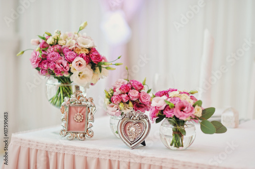 Красивые розовые букеты в вазах на столе