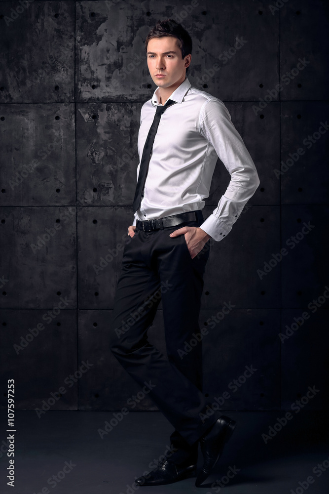 Full height portrait handsome businessman on black background 
