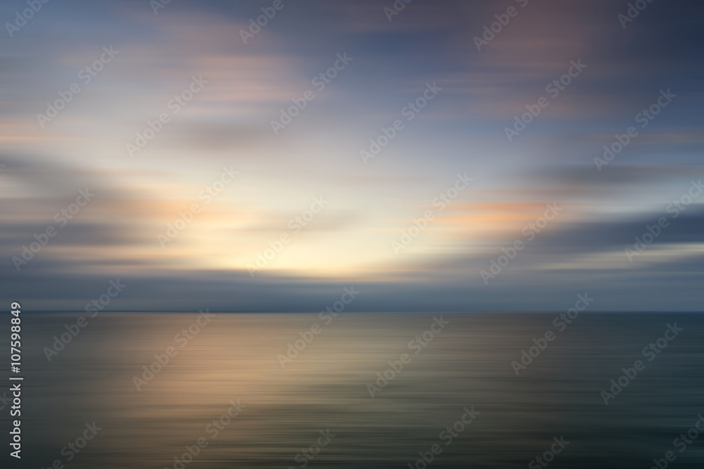Beautiful vibrant sunrise landscape over calm sea wtih blur filt