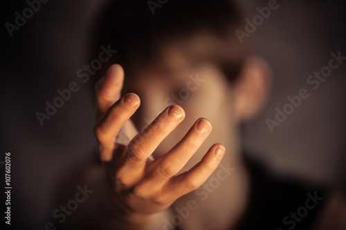 Open hand reaching out from obscured face photo