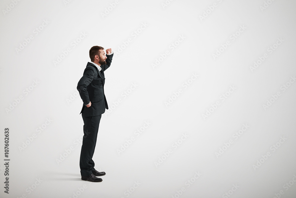 A bearded man in a black business suit looks into the distance A bearded man in a black business suit looks into the distance