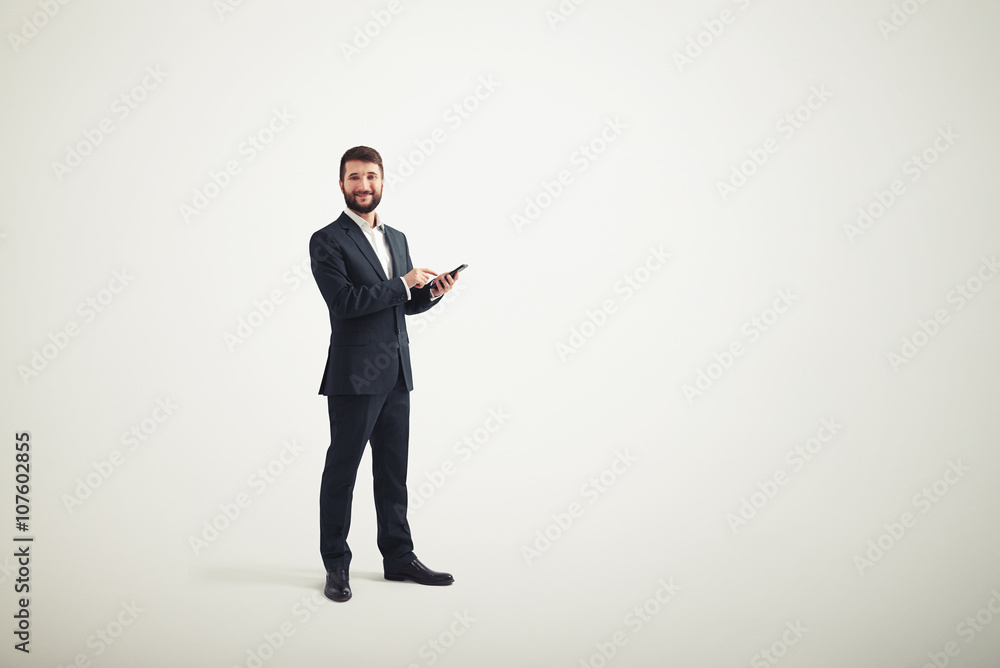 Businessman in a formal wear with black phone in his hands Businessman in a formal wear with black phone in his hands