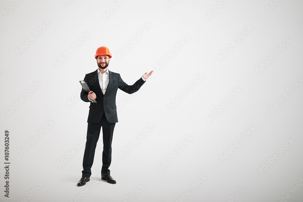 Man in formal wear and a construction helmet pointing in the dir Man in formal wear and a construction helmet pointing in the dir