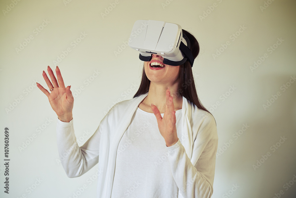 Woman having fun using white virtual reality headset Woman having fun using white virtual reality headset