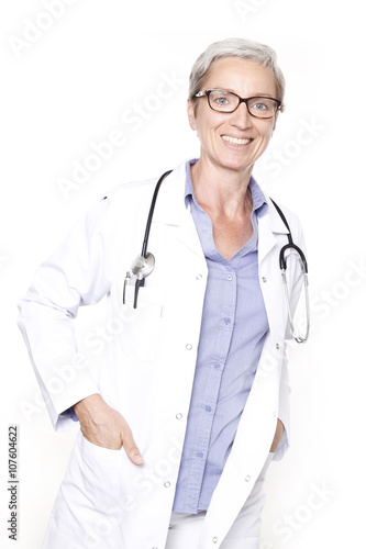 Ärztin mit Kittel und Stethoskop mit Händen in den Taschen