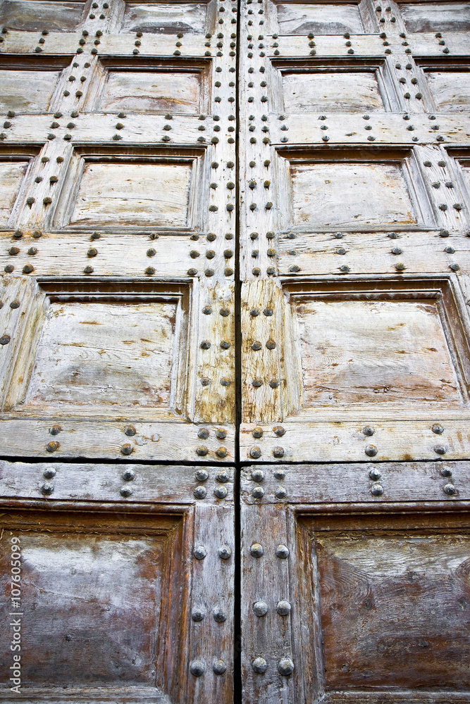 Detail of an old wooden doorway with metal nails reinforcement Detail of an old wooden doorway with metal nails reinforcement