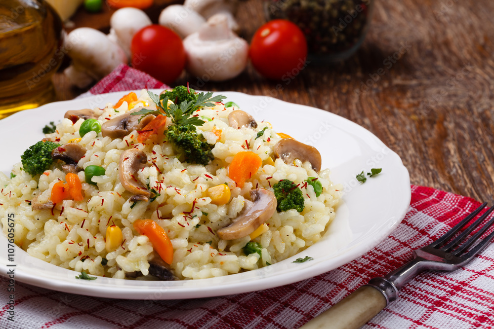 Classic Risotto with mushrooms and vegetables served on a white Classic Risotto with mushrooms and vegetables served on a white