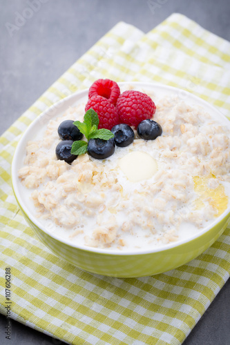 Oatmeal porridge in bowl with berries raspberries and blackberri