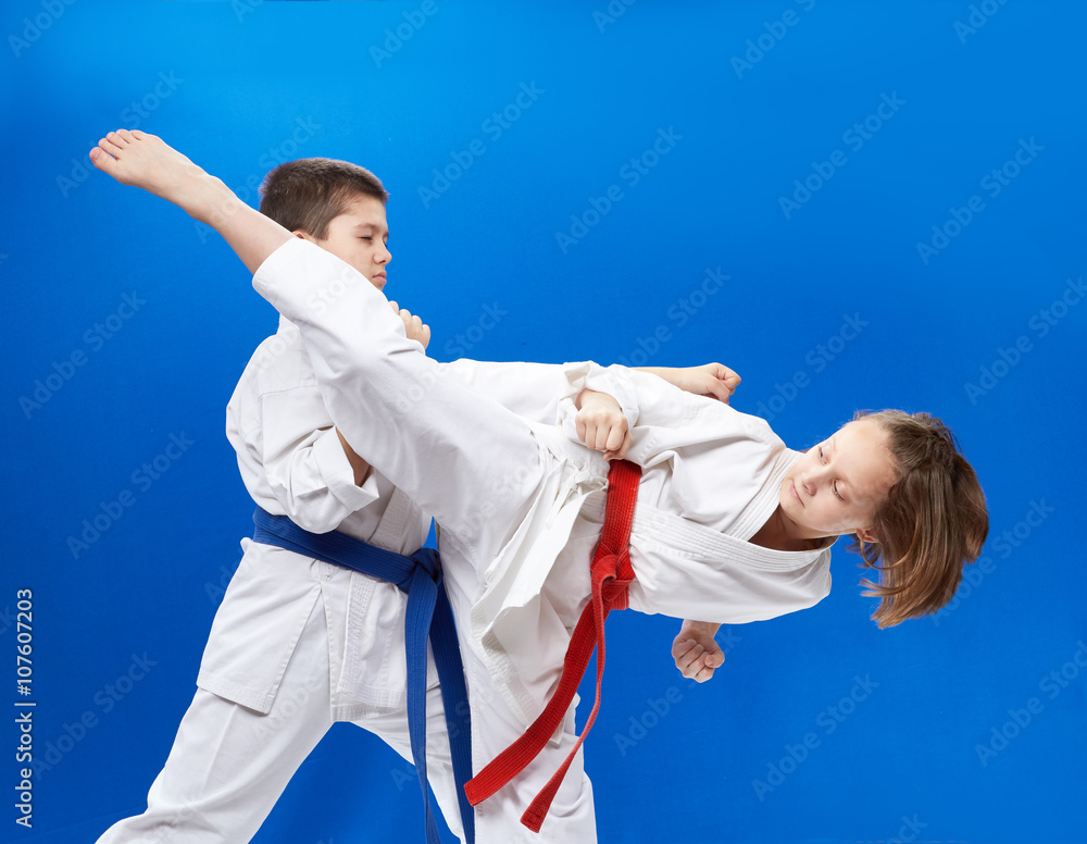 Girl and boy in karategi are training karate blows Girl and boy in karategi are training karate blows